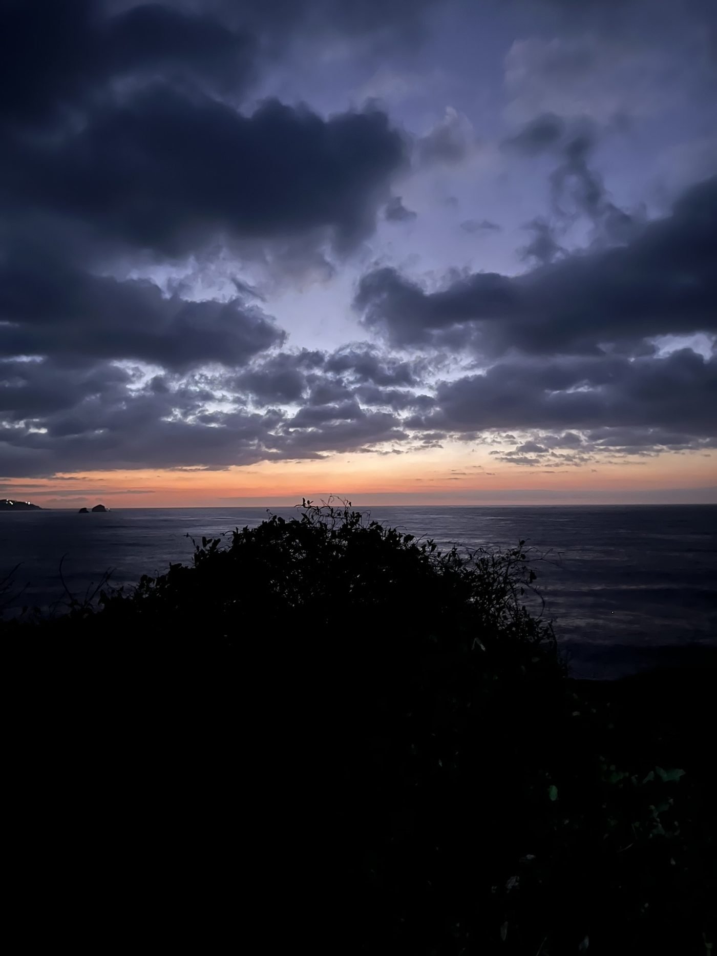 Cielo nublado al anochecer sobre el mar en Punta Cometa, con franja naranja en el horizonte